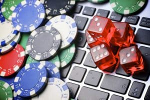 clavier d'ordinateur portable couvert de jetons et de dés de casino